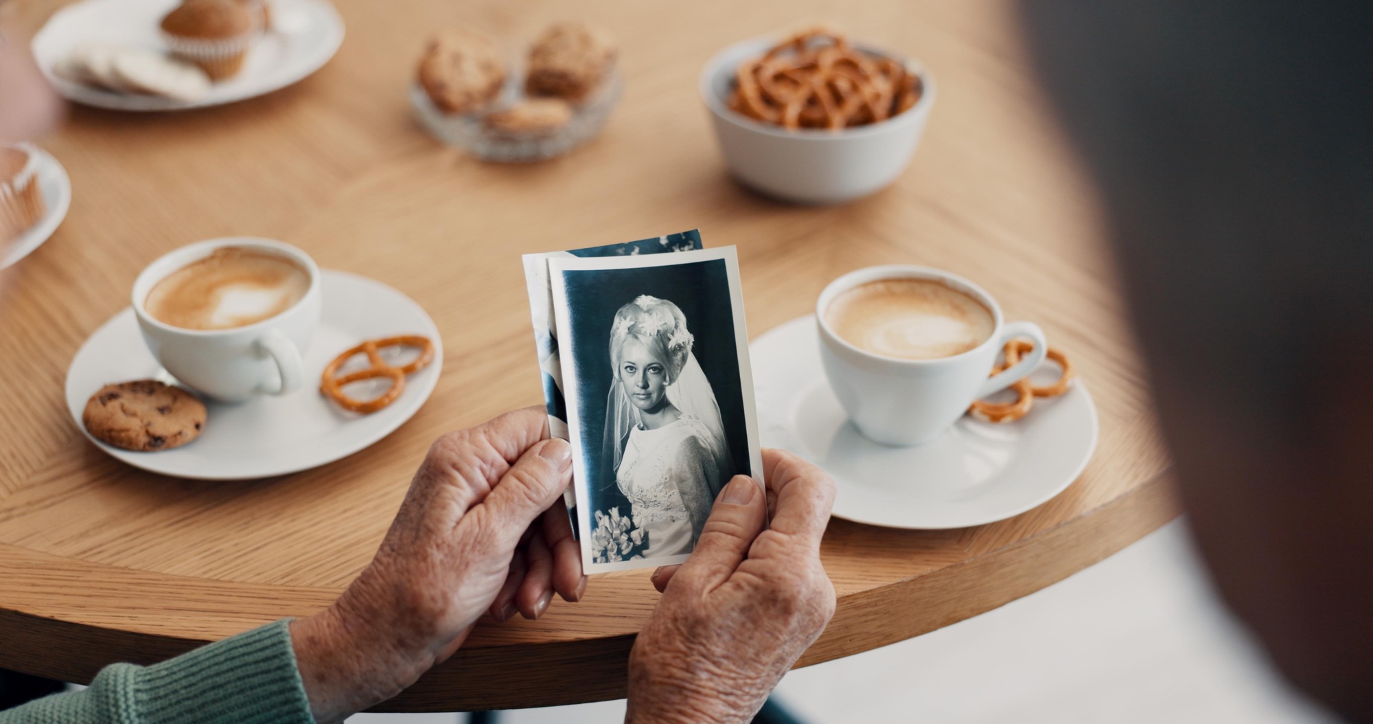 Elderly hands holding black and white photograph of a bride